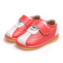 Zapatos rojos y blancos del niño del niño